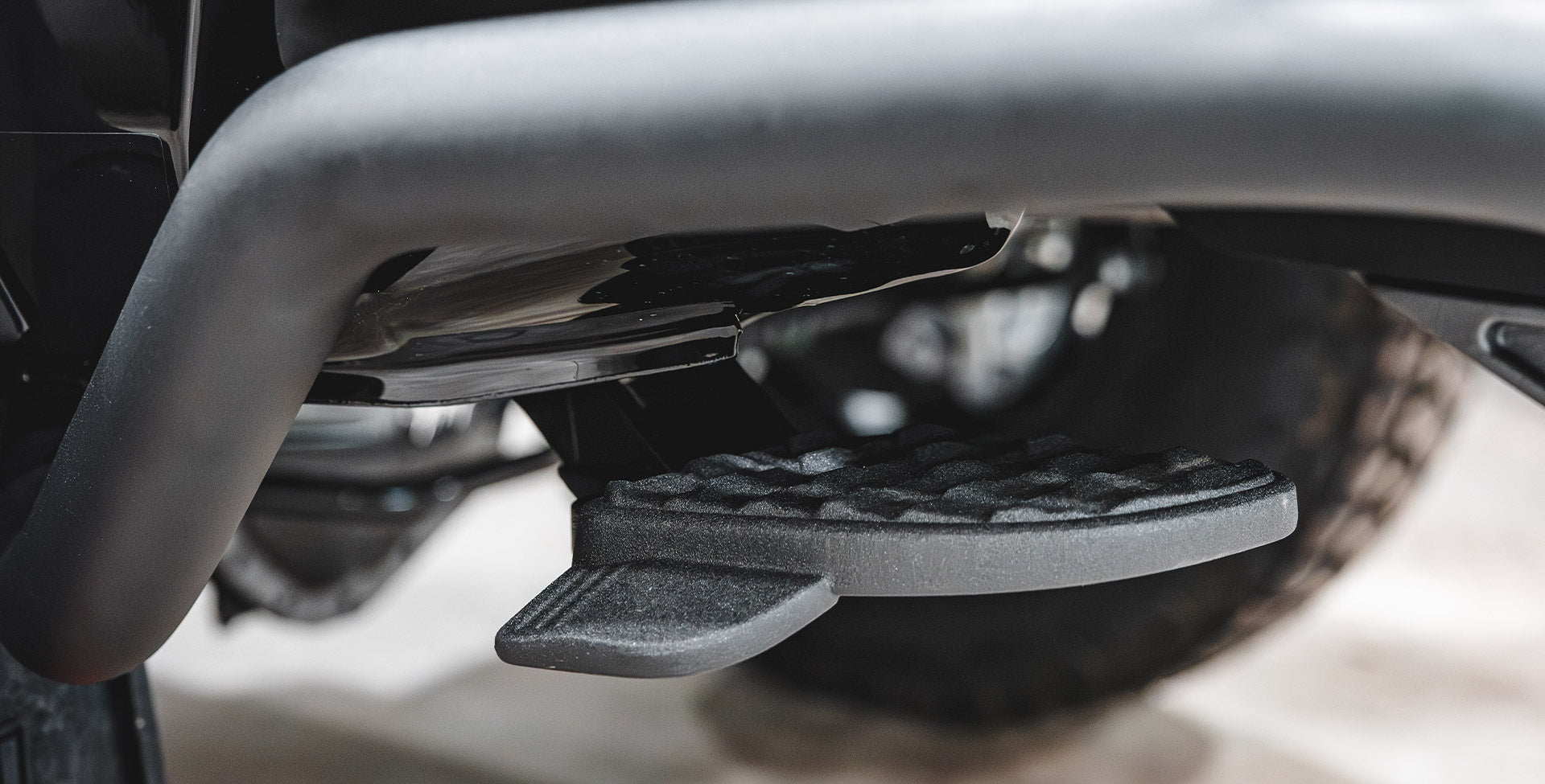 Rear step in the retracted position under rear bumper on vehicle | The Mopar® Bed Step shown in the retracted position