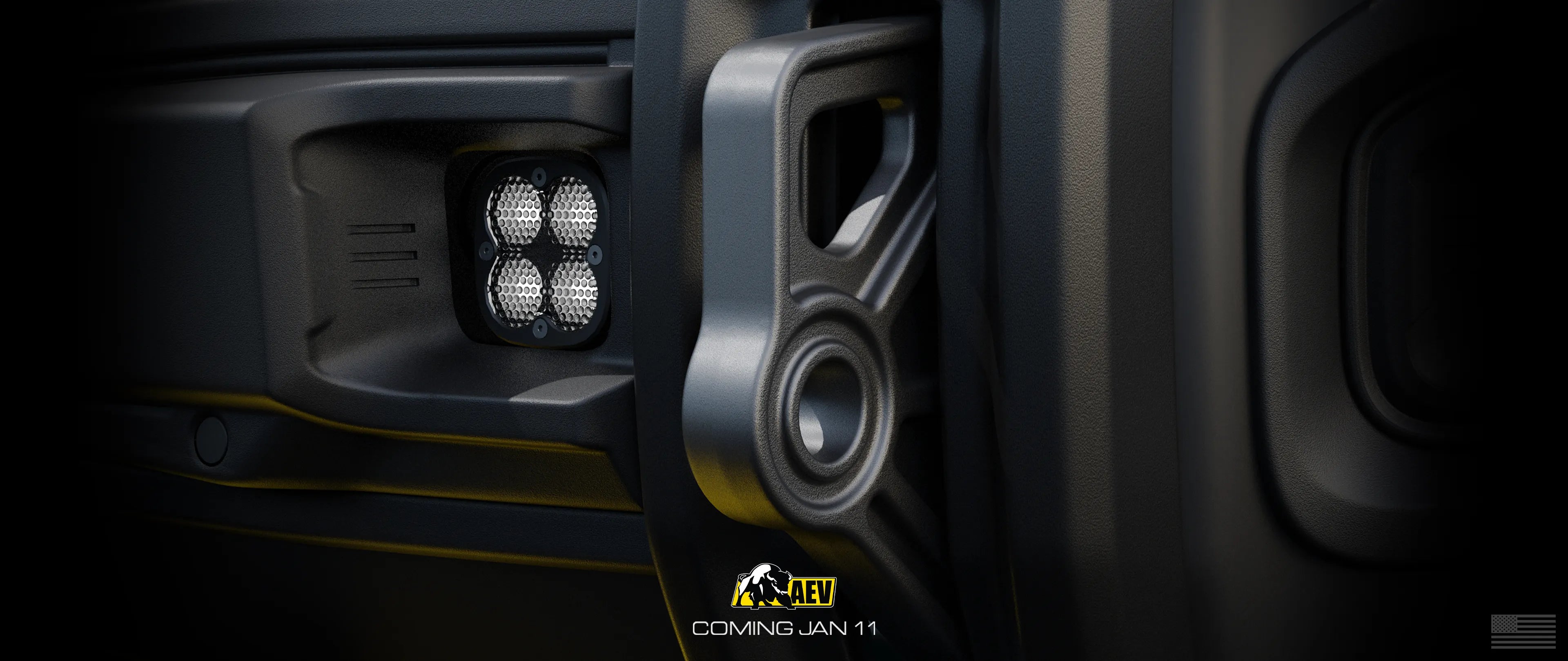 Close-up of a vehicle's bumper with a light and AEV logo.