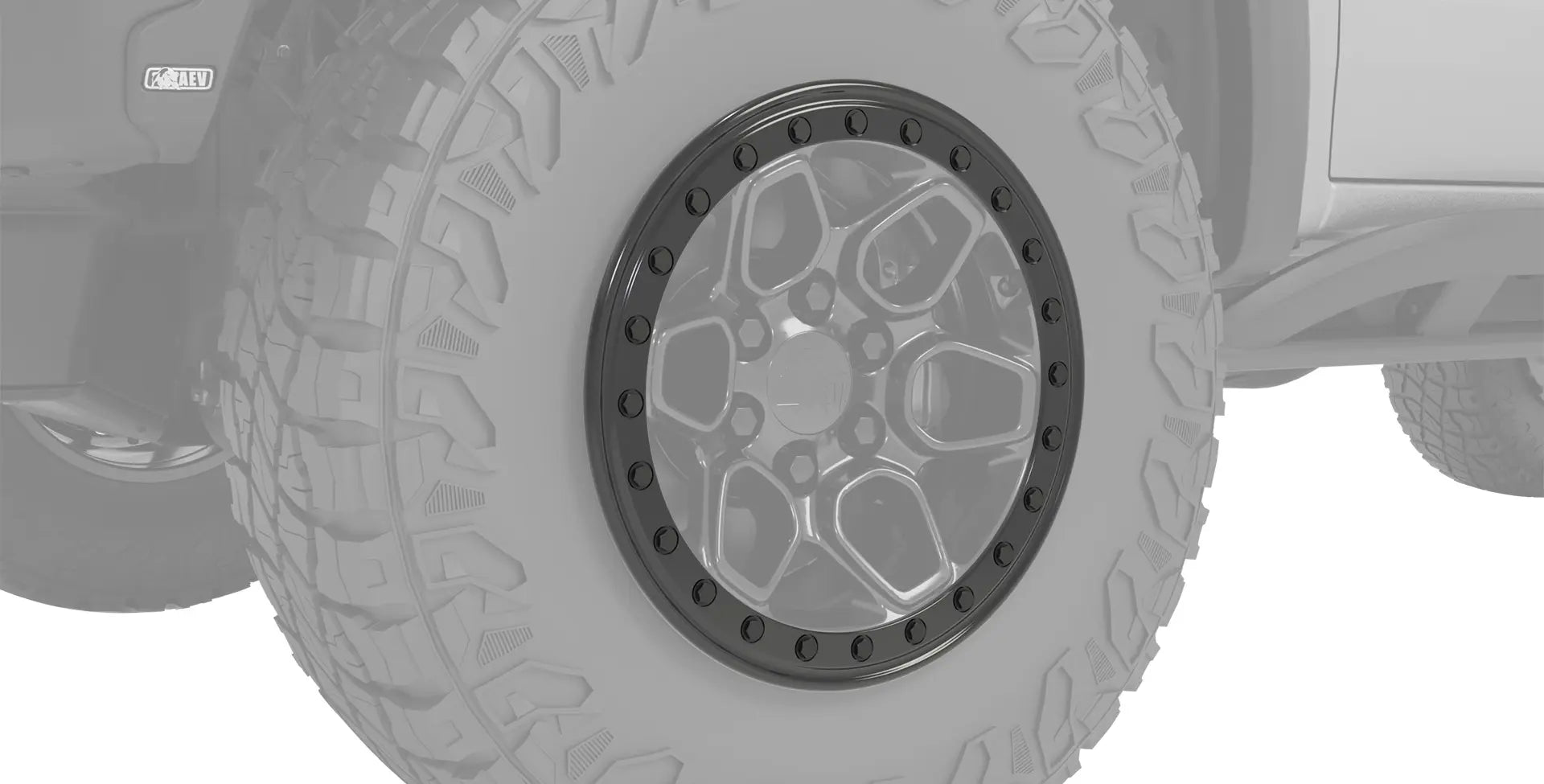 Close-up of a tire with a detailed rim on a vehicle, likely for off-road use. | Satin Black Protection Ring on OE Crestone Wheel